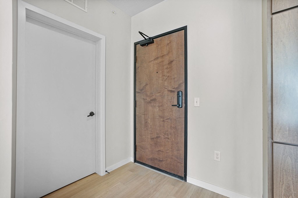 A white door is on the left and a wooden door is on the right.
