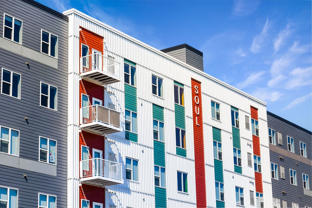 a colorful apartment building with a blue sky in the background