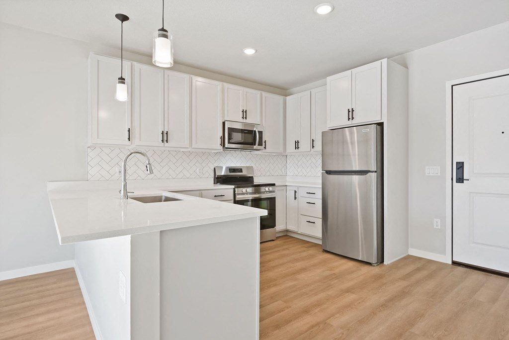 a renovated kitchen with white cabinets and stainless steel appliances