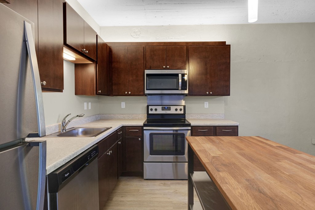 a kitchen with wooden cabinets and stainless steel appliances