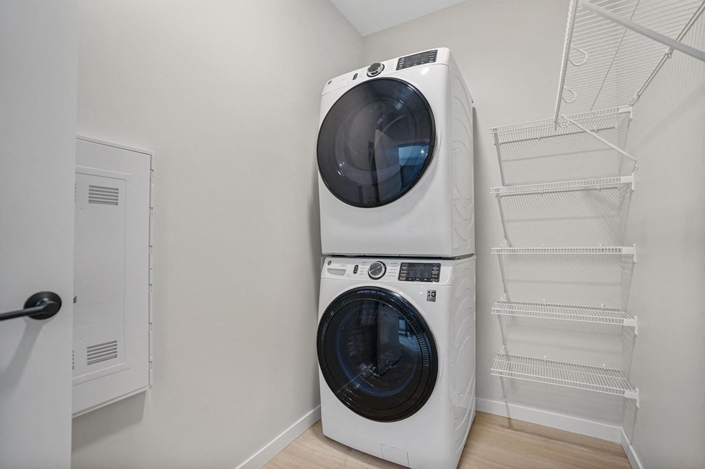 A white front loading washing machine in a laundry room.