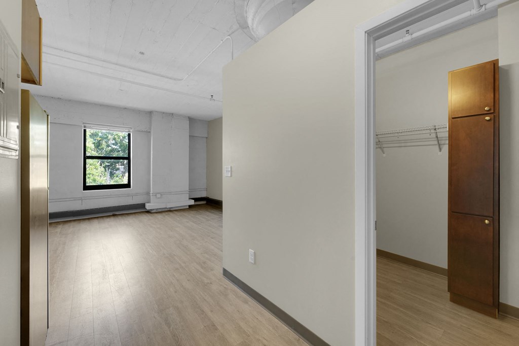 a bedroom with hardwood floors and white walls