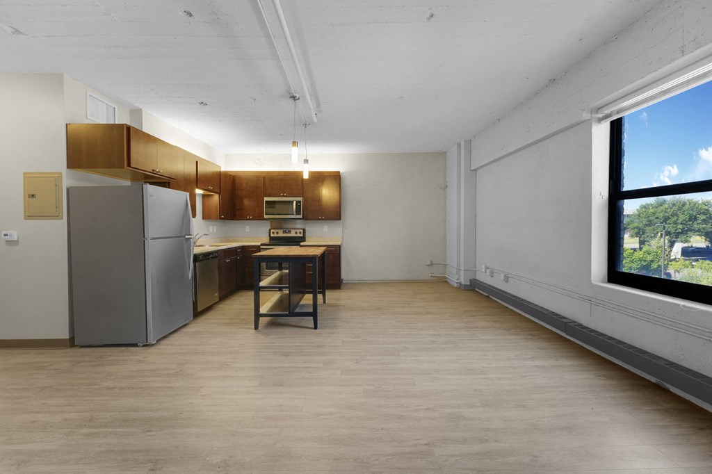 a kitchen with a refrigerator freezer next to a window