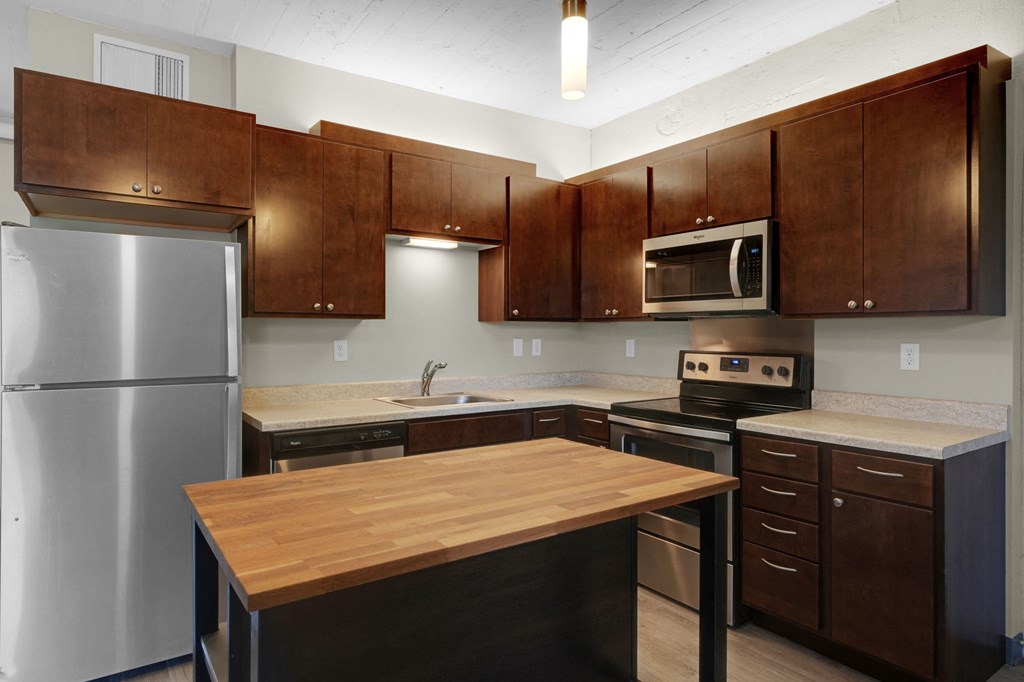 a kitchen with wooden cabinets and stainless steel appliances