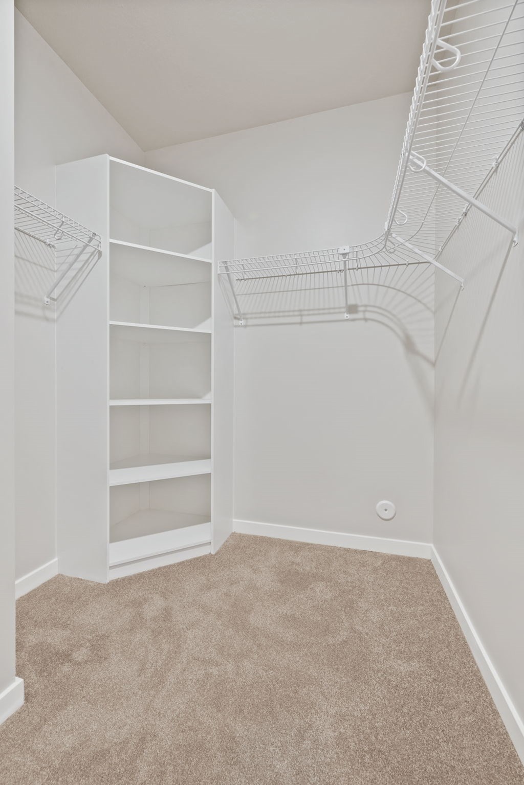 a closet in a bedroom with shelves and a white closet