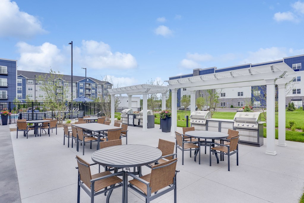 an outdoor patio with tables and chairs and a pergola