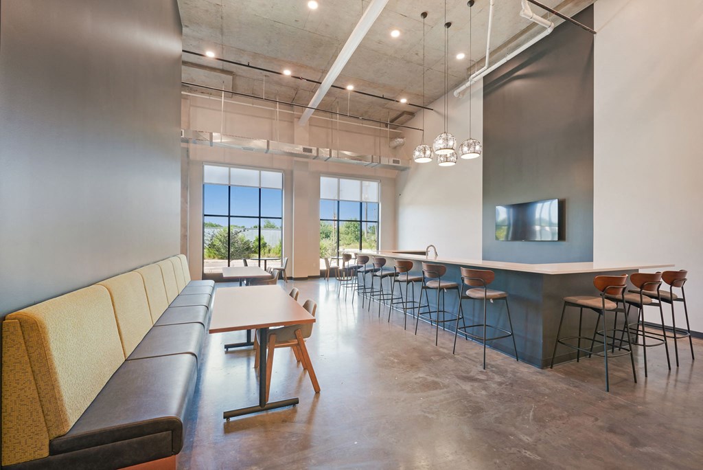 a communal area with tables and chairs in a room with couches and chairs