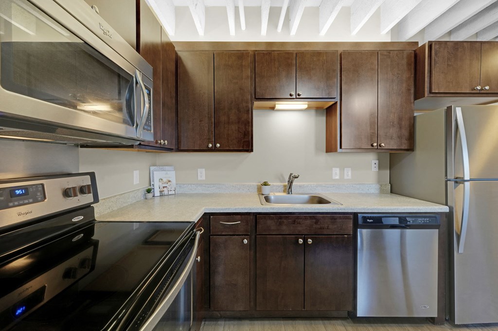 a kitchen with dark wood cabinets and stainless steel appliances