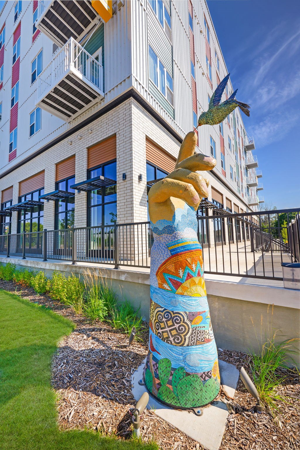 a statue of a hand holding a bird in front of a building