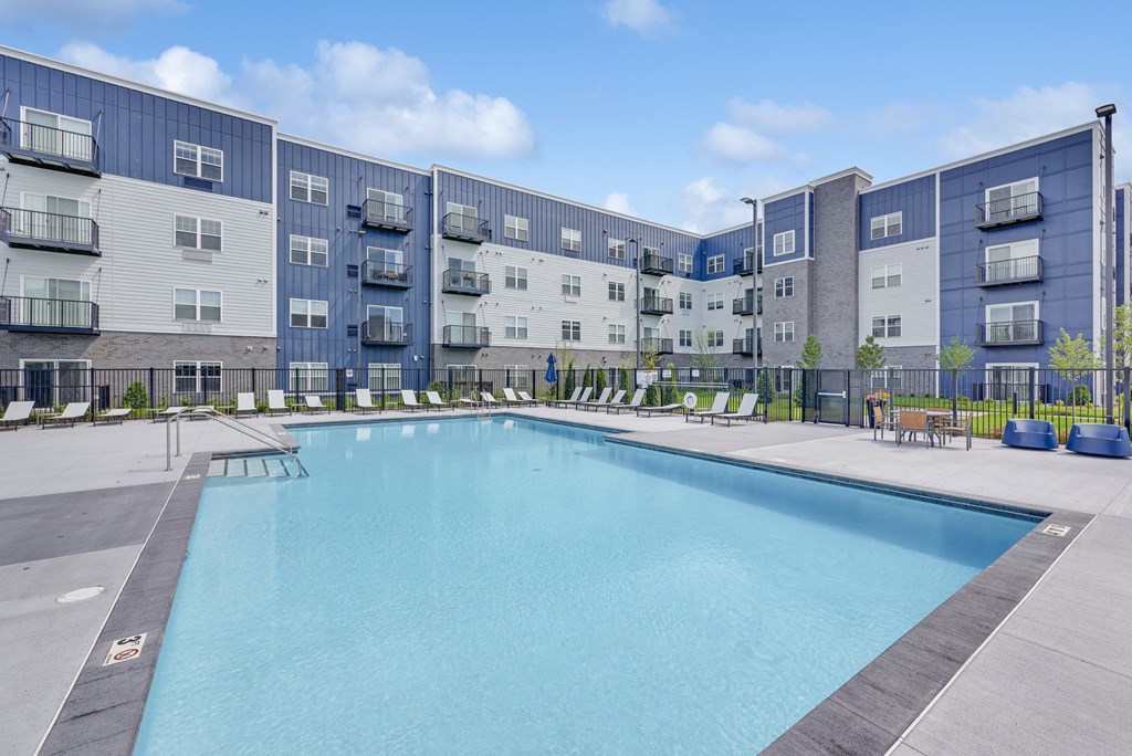 a swimming pool with an apartment building in the background