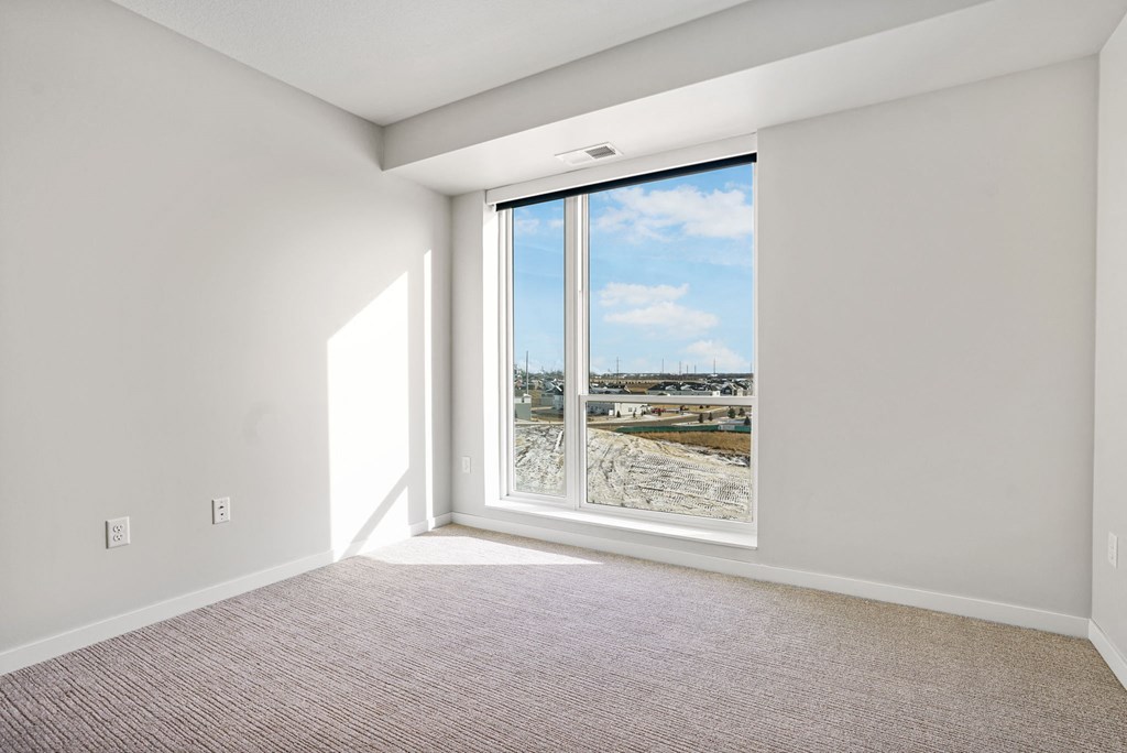 A room with a large window overlooking a snowy landscape.