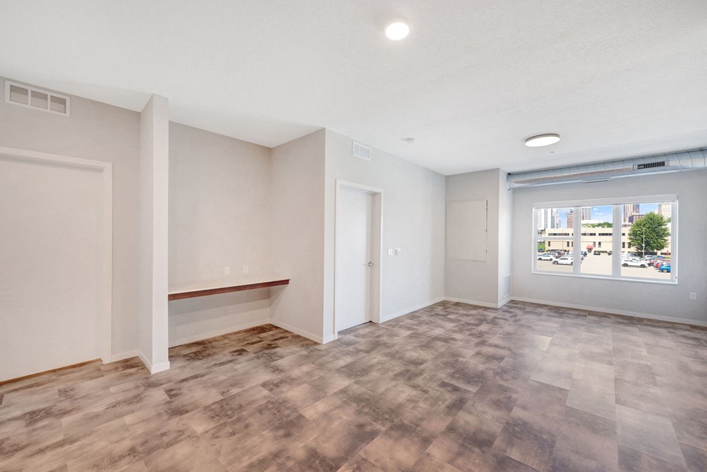 an empty living room with a window and a door
