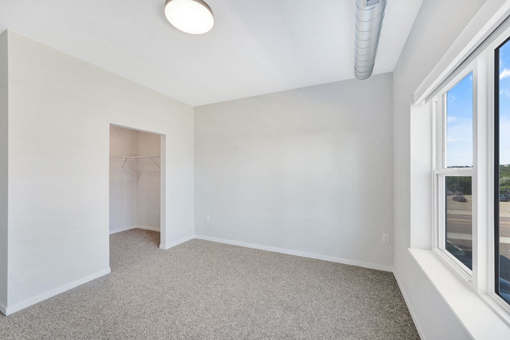 an empty room with two windows and a closet