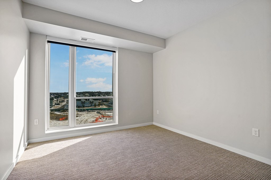A room with a large window overlooking a beach.