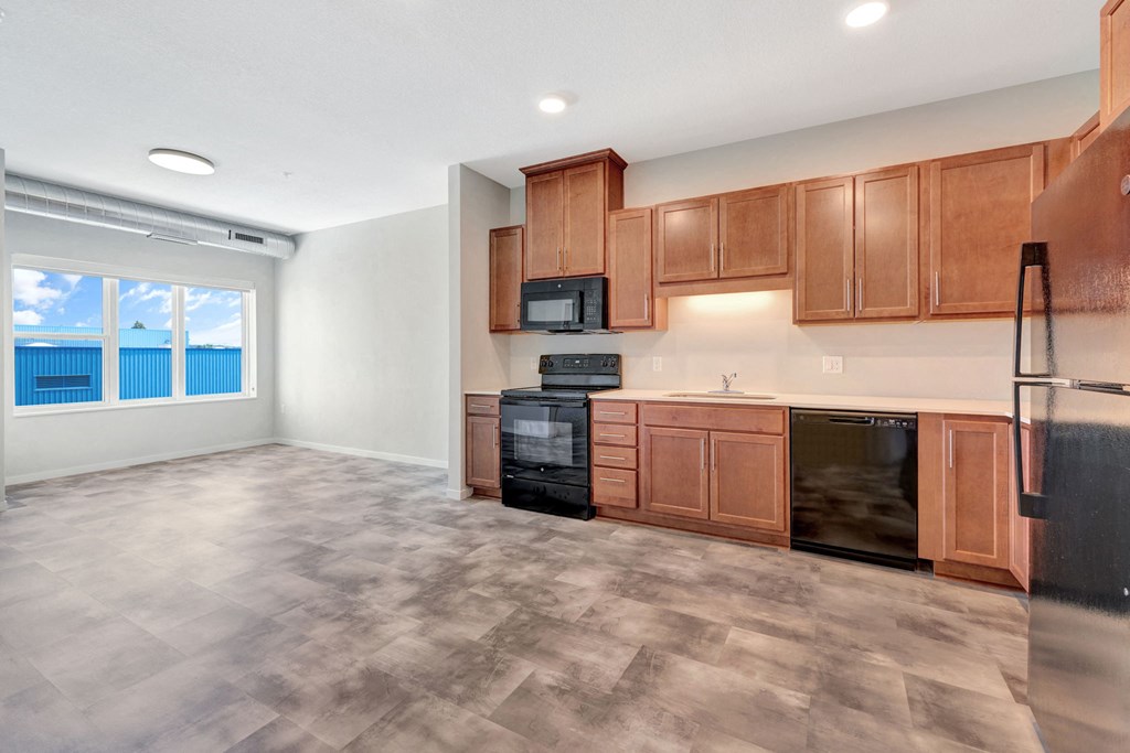 an empty kitchen with wood cabinets and stainless steel appliances