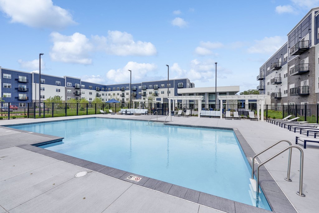 a swimming pool in a building with apartments in the background