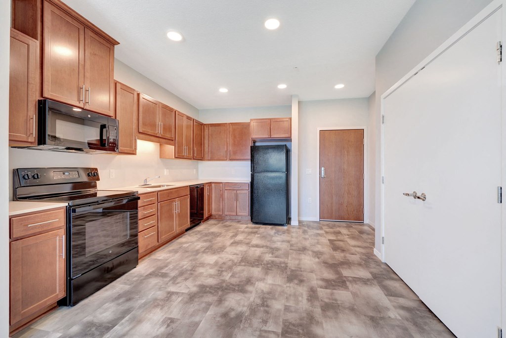 a kitchen with wooden cabinets and a stainless steel refrigerator