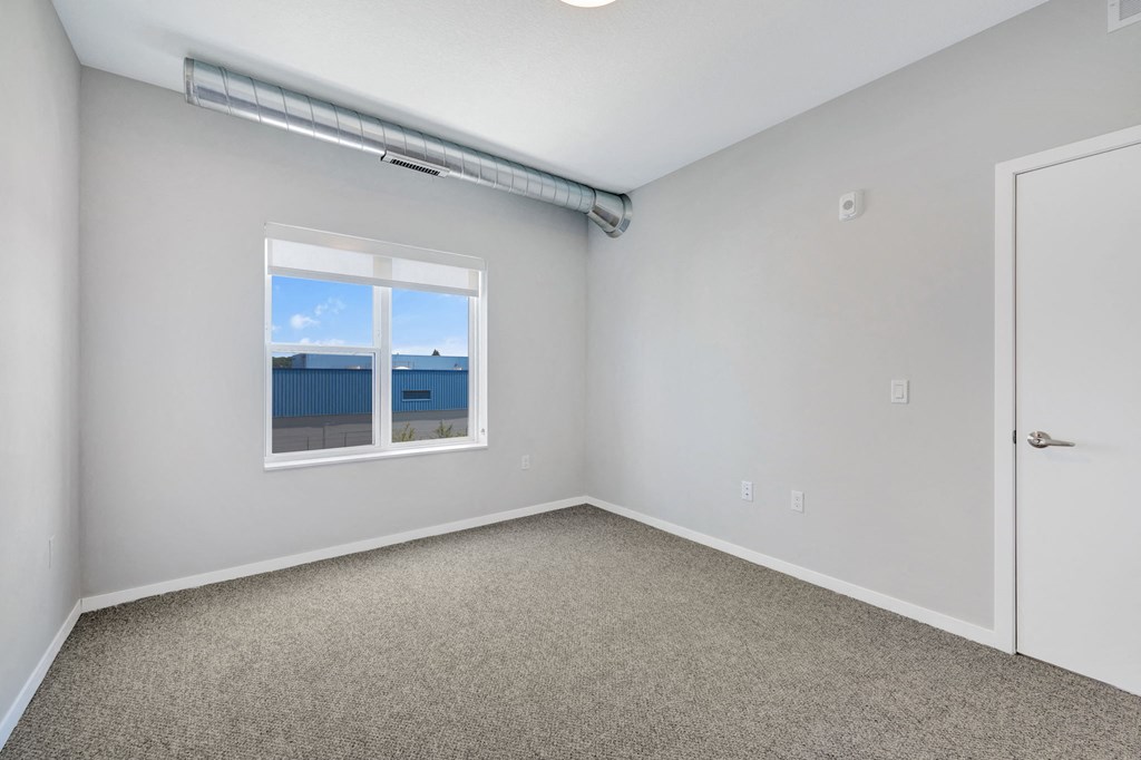 an empty room with carpet and a window