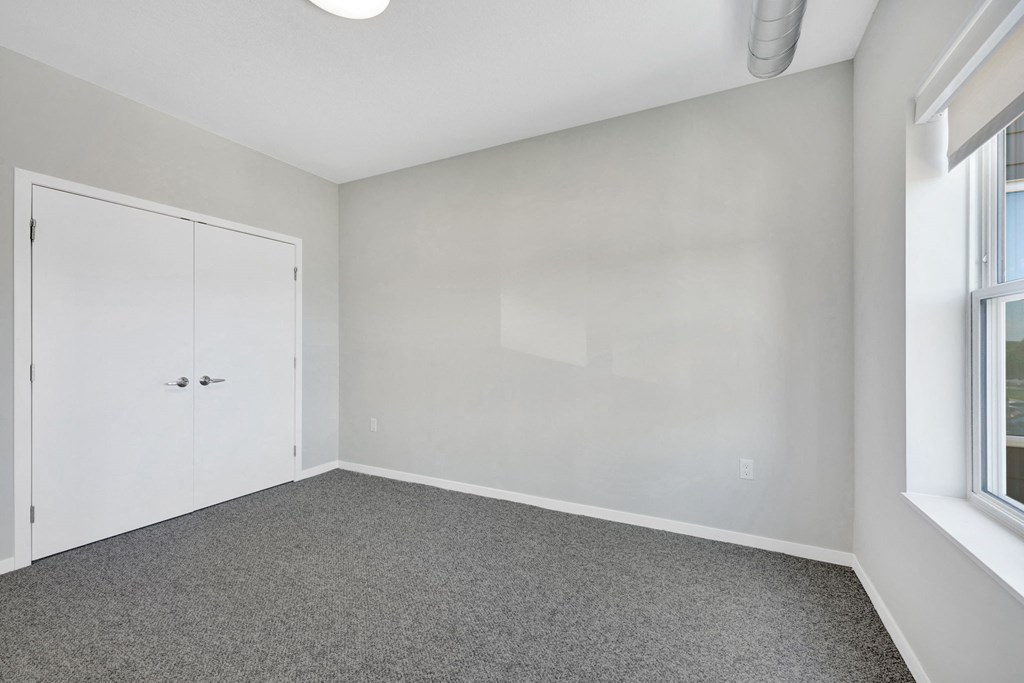 an empty bedroom with white walls and a closet