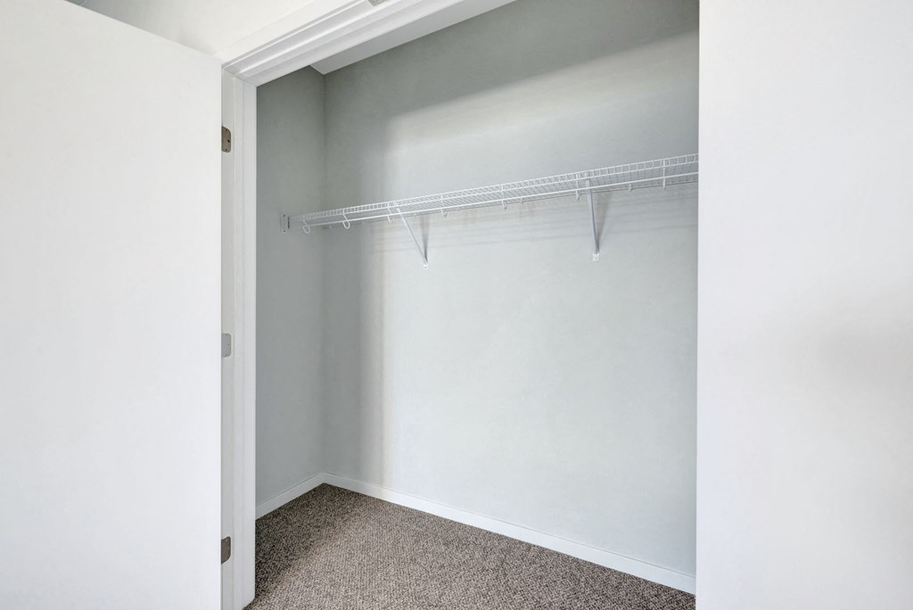 an empty closet in an empty room with white walls and a window
