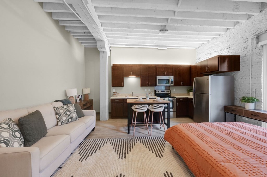 a bedroom with a bed and a refrigerator in a room