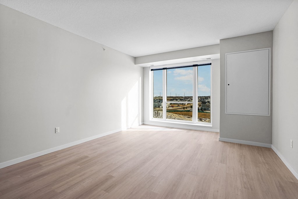 A room with a sliding glass door leading to a balcony.