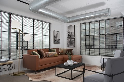 a living room with a brown couch and a glass coffee table