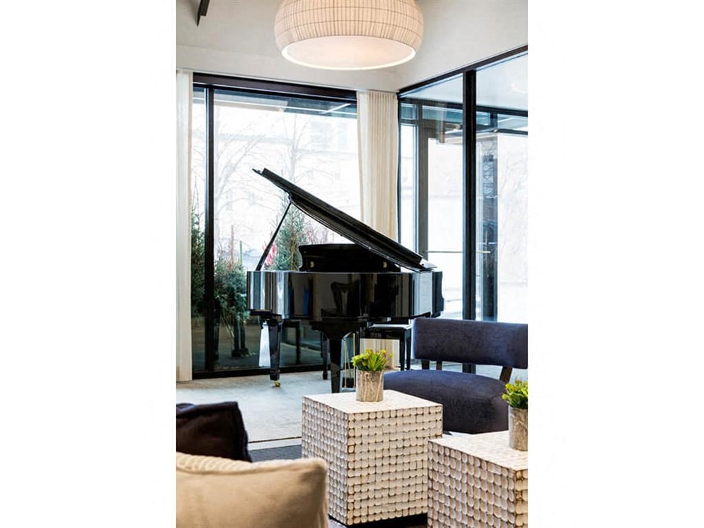Lobby with black grand piano and windows