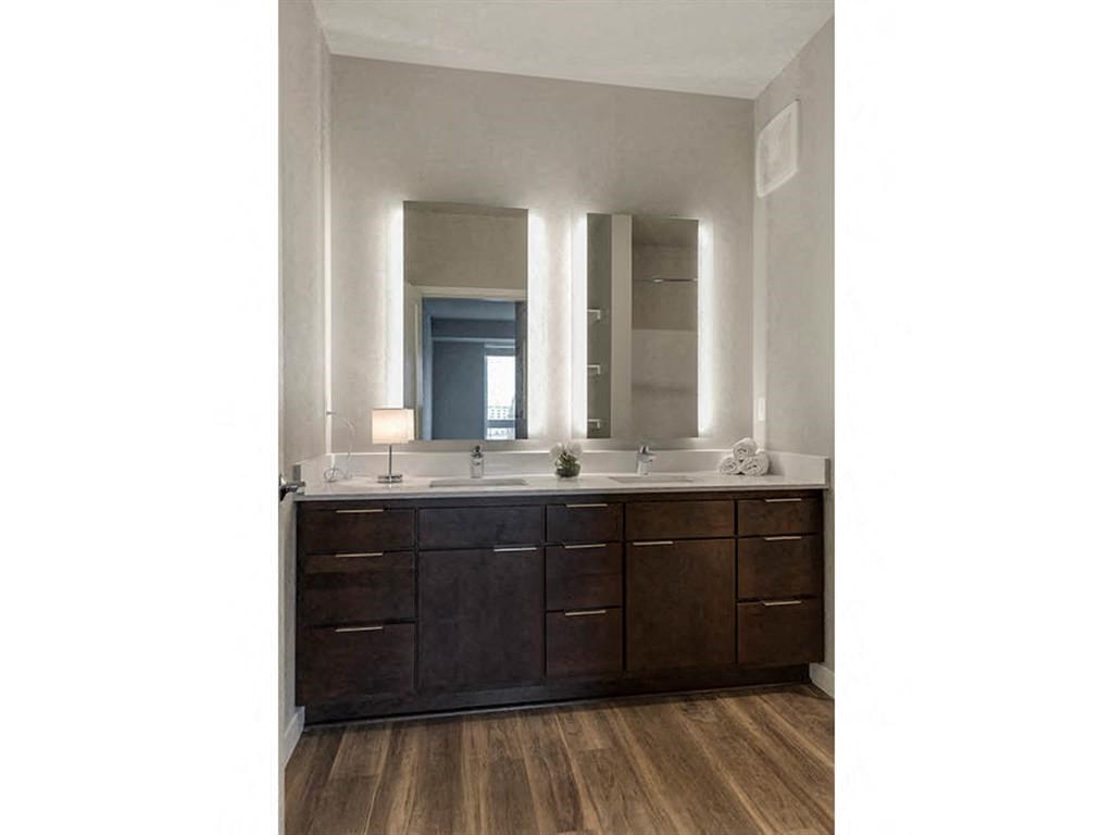 Bathroom with double vanity and backlit mirrors
