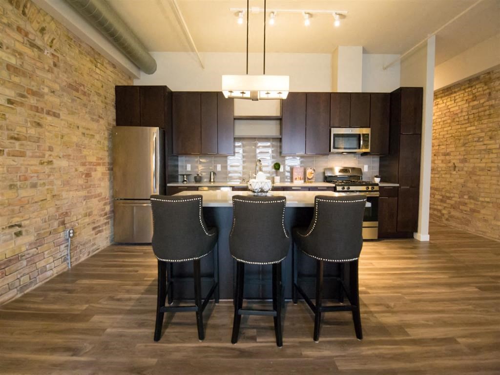 Kitchen with stainless steel appliances and exposed brick wall