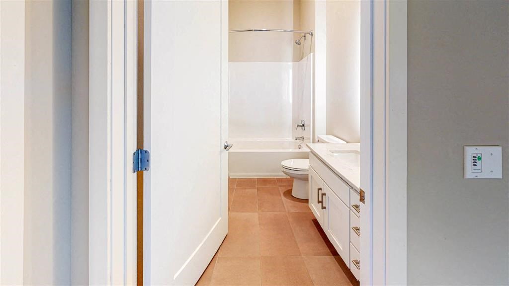 bathroom with white vanity and bathtub