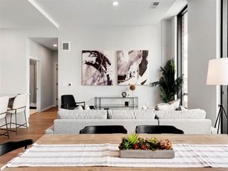 Modern white living room and dining room with high ceilings and artwork