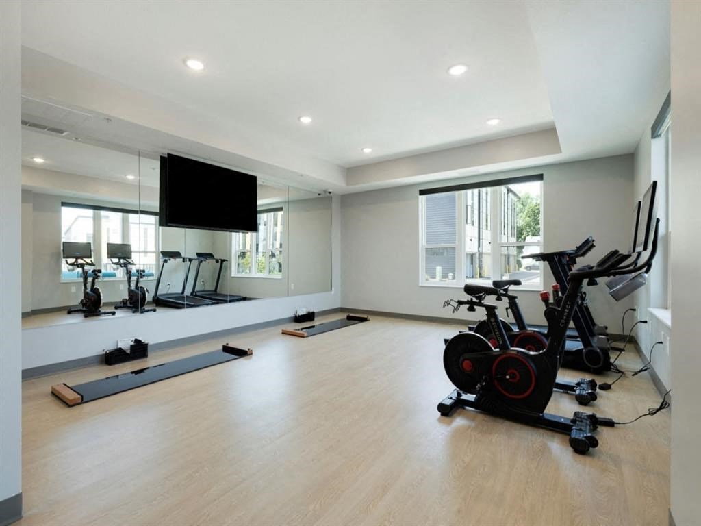 a gym with a tv and exercise equipment