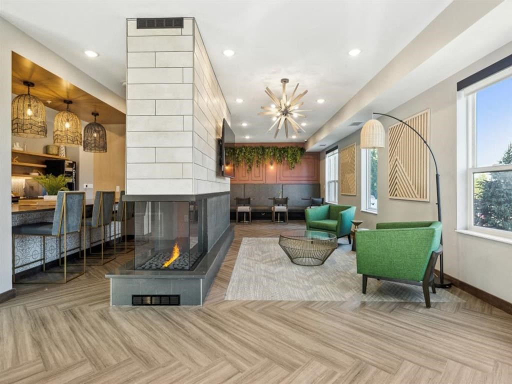 a living room with a fireplace and a kitchen in the background