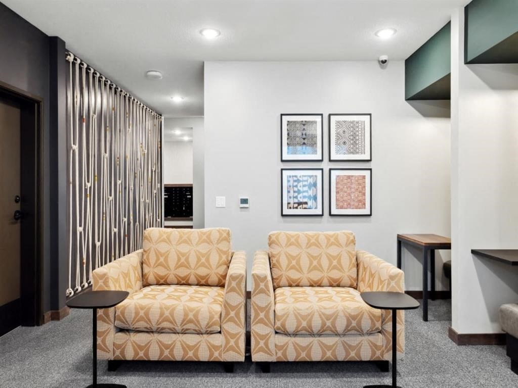 a room with two chairs and some pictures on the wall