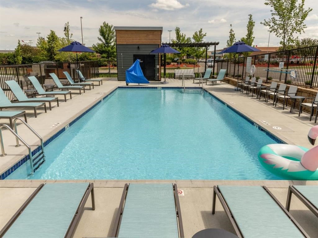 a swimming pool with chaise lounge chairs and umbrellas
