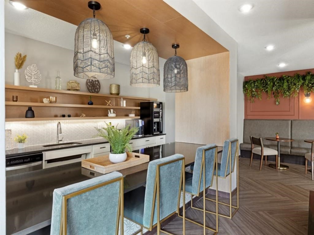 a kitchen with a long counter and blue chairs