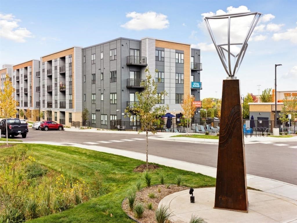 a sculpture in a grassy area with a building in the background
