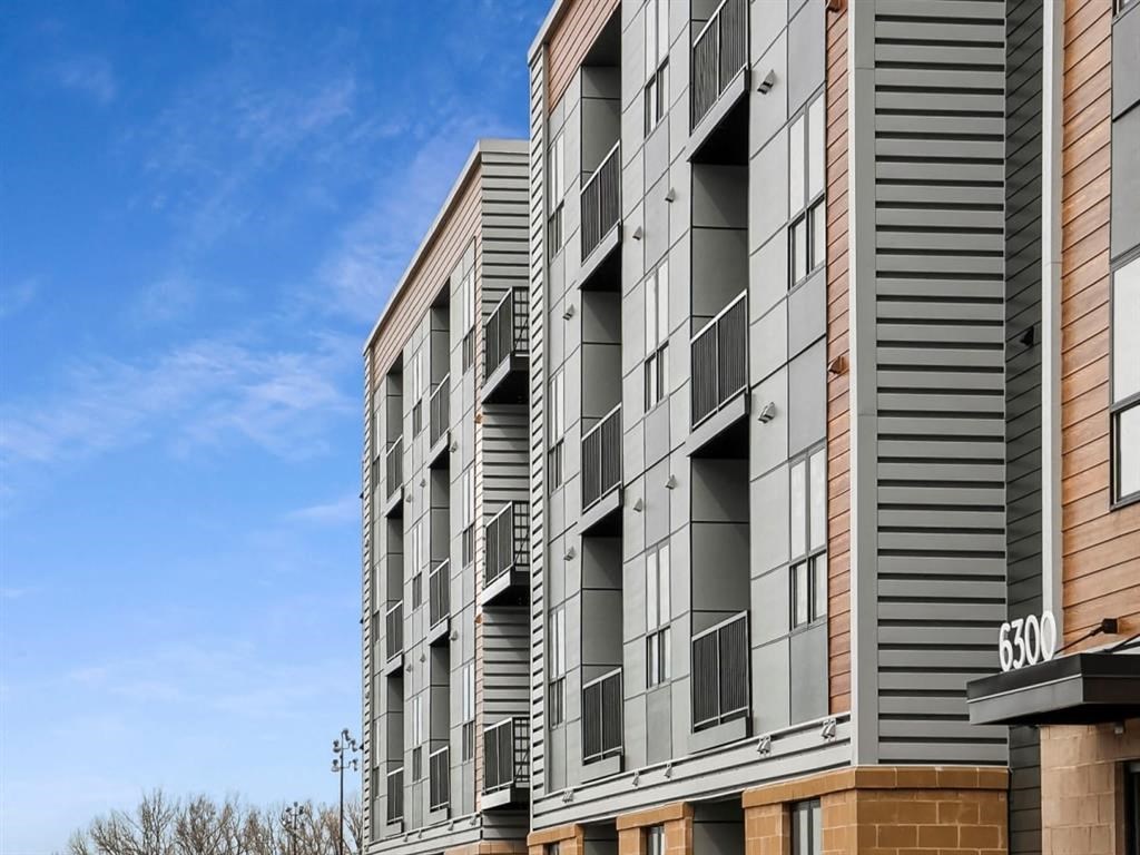 a large apartment building with balconies and a blue sky in the background