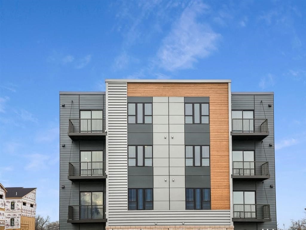 a large apartment building with a blue sky in the background