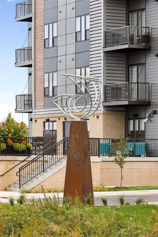 a statue of a bird in front of an apartment building