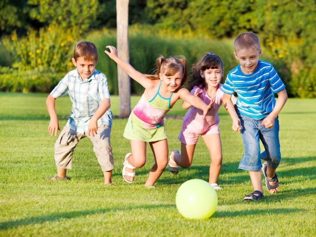 a group of children playing with a ball on the grass