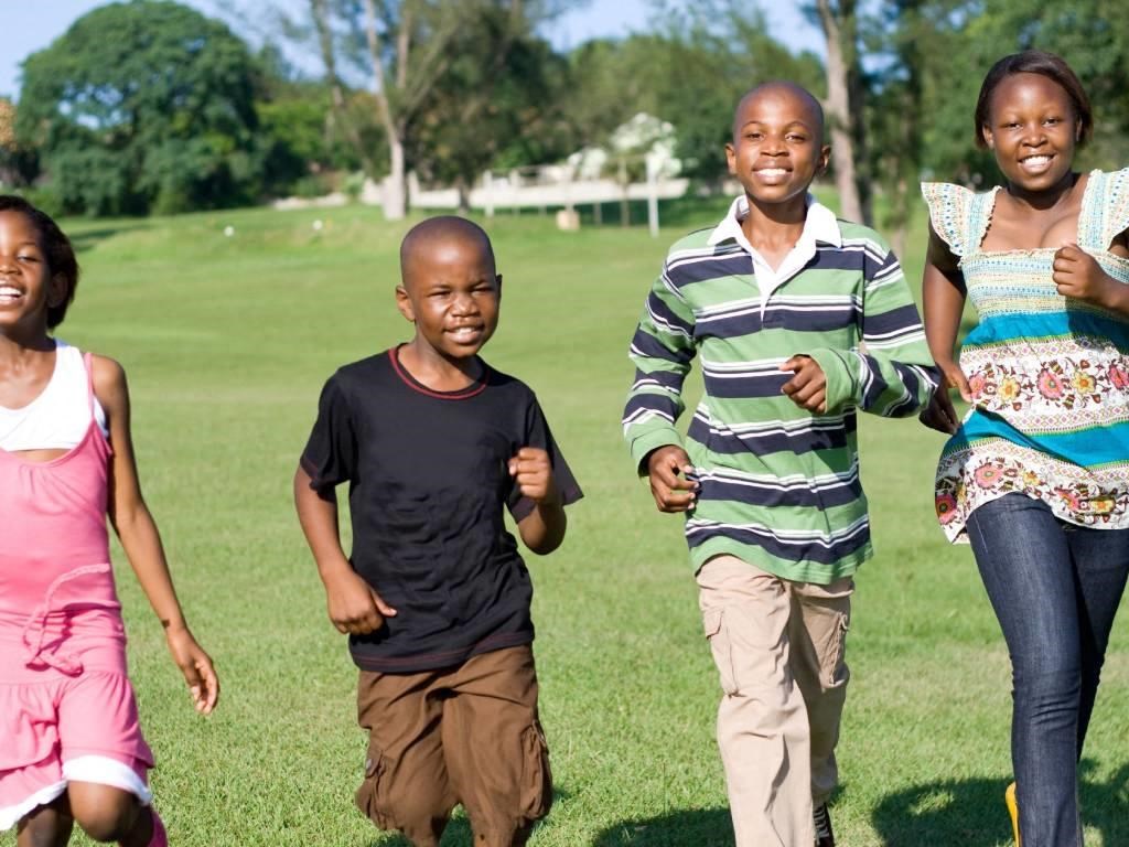 a group of children running in the park