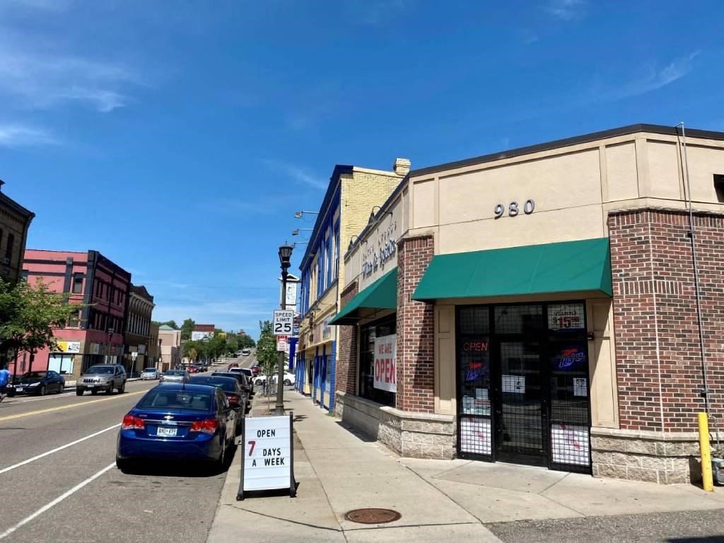 a small town street with cars parked on the side of the road