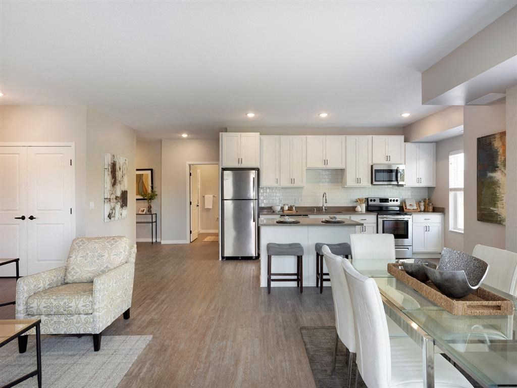 Open layout kitchen, dining and living room with white cabinets