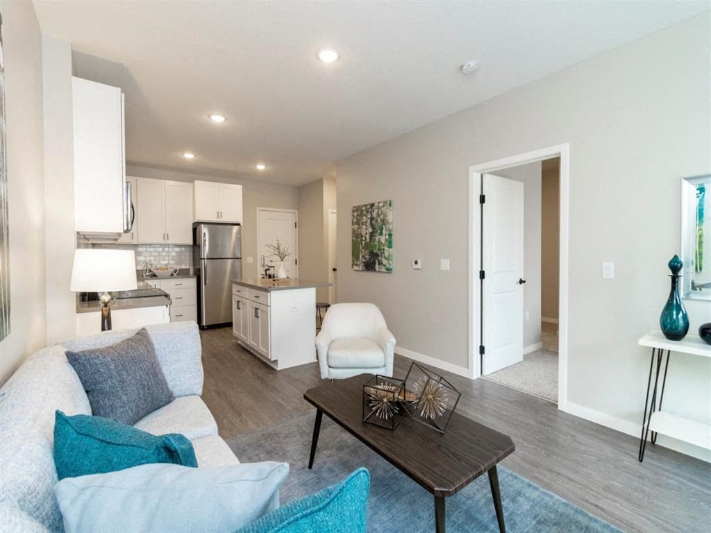 Living room with couch and coffee table with view into the island kitchen