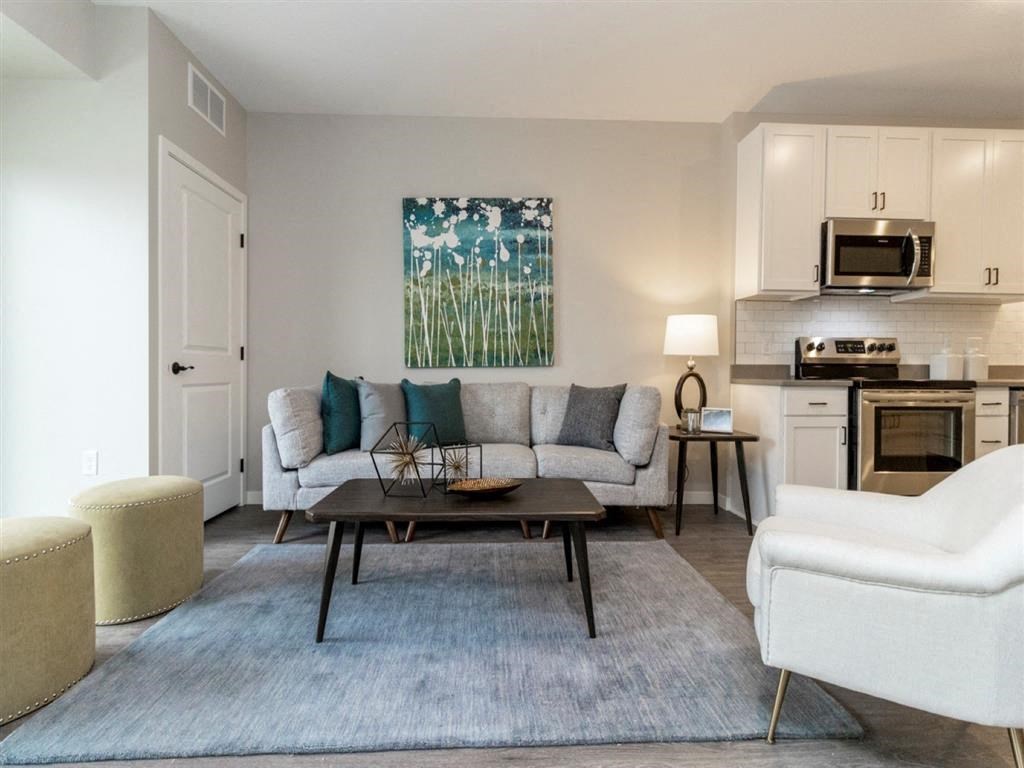 Living room with couch and coffee table open to the kitchen