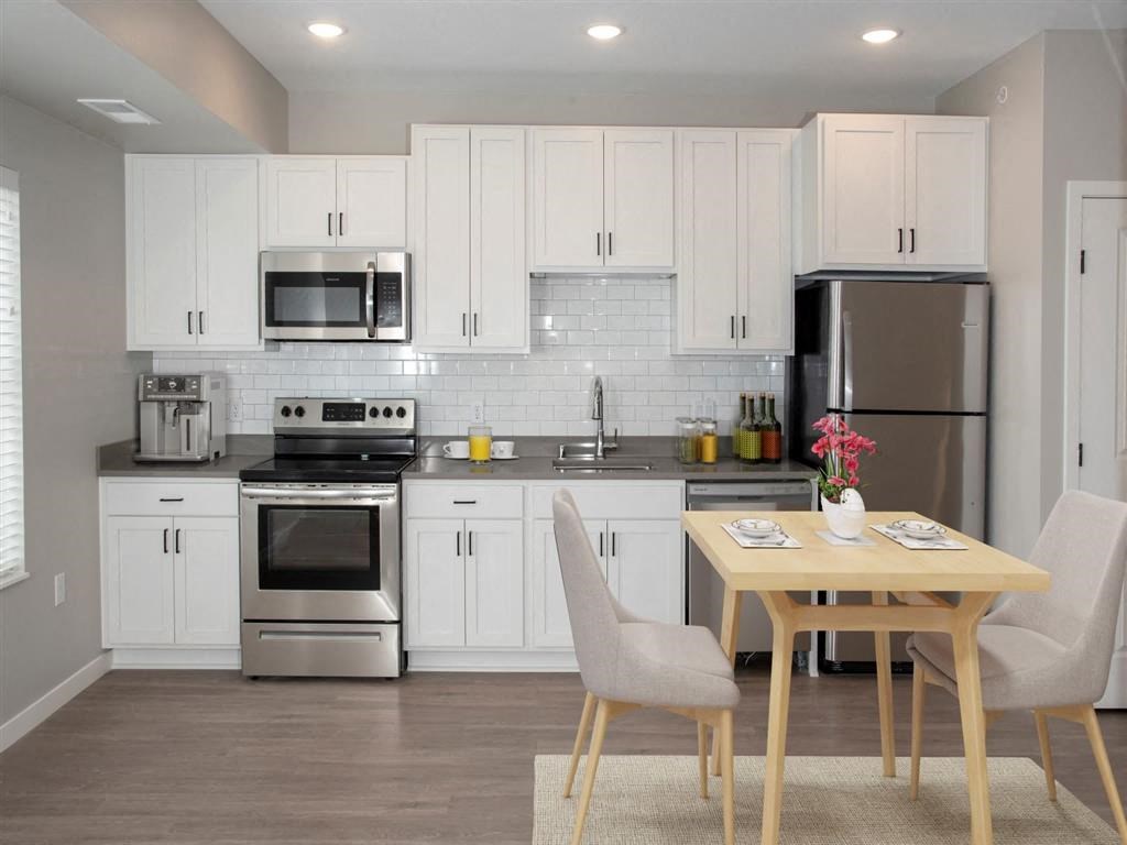 studio kitchen with white cabinets and stainless steel appliances