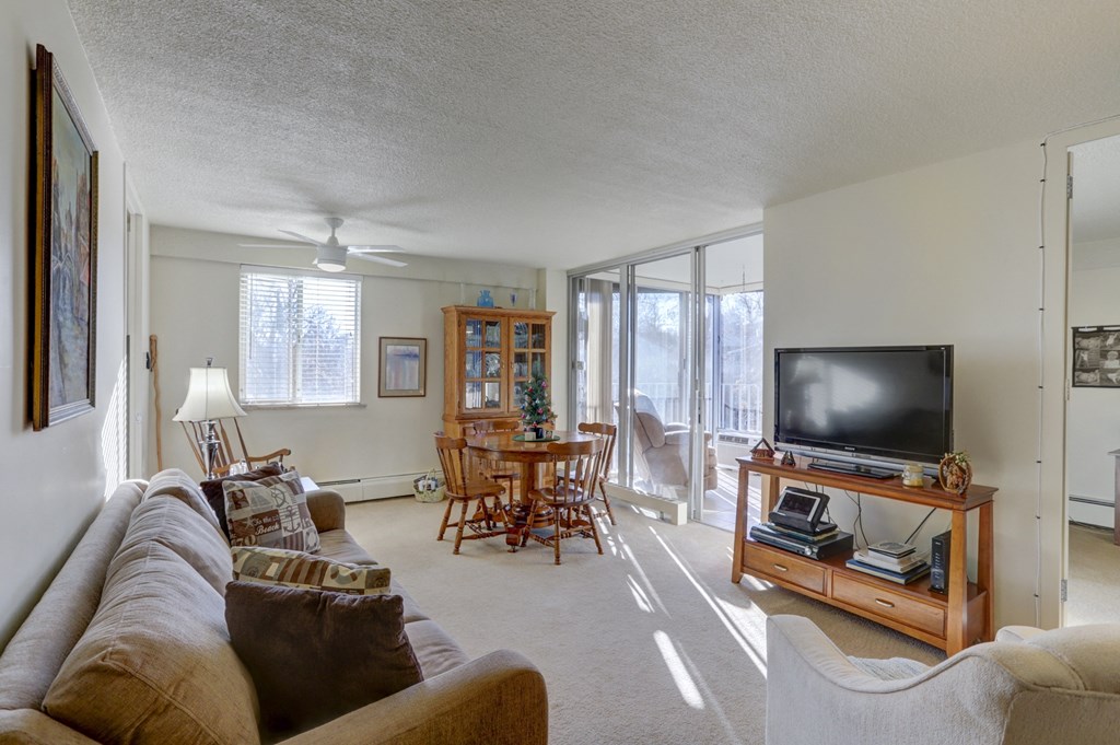 the living room is open to the dining room and the balcony