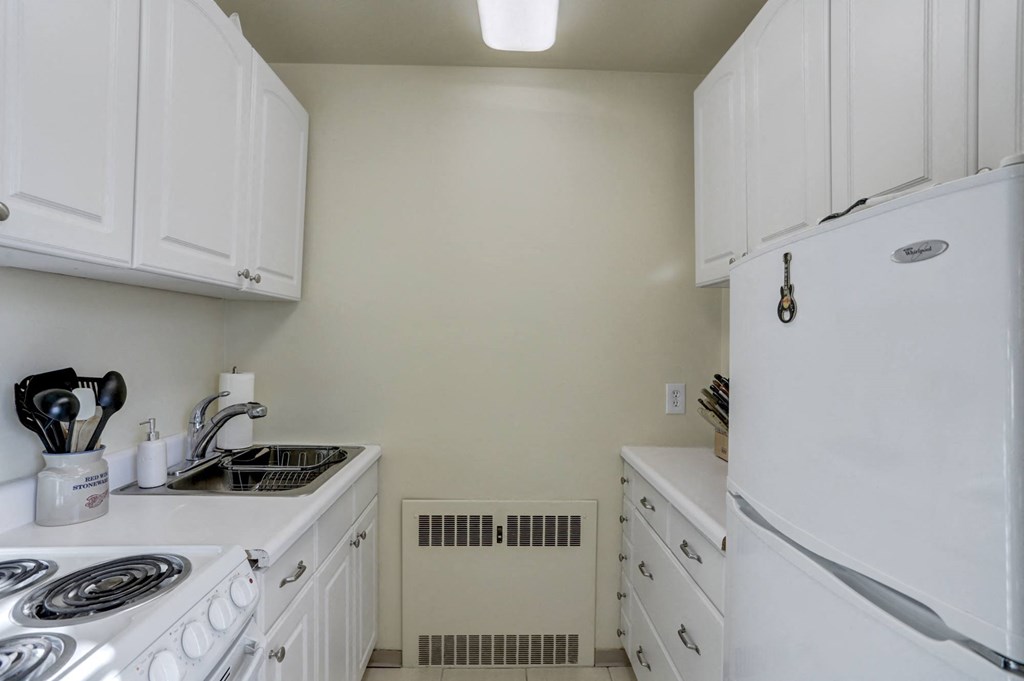 a kitchen with white cabinets and a stove and a refrigerator